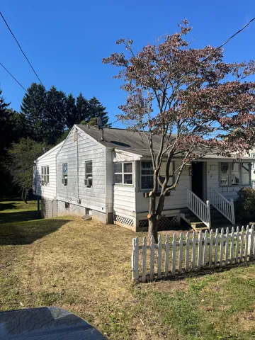 a view of a yard in front of a house with wooden fence
