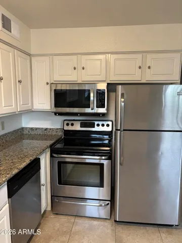 a kitchen with granite countertop a stove and a microwave