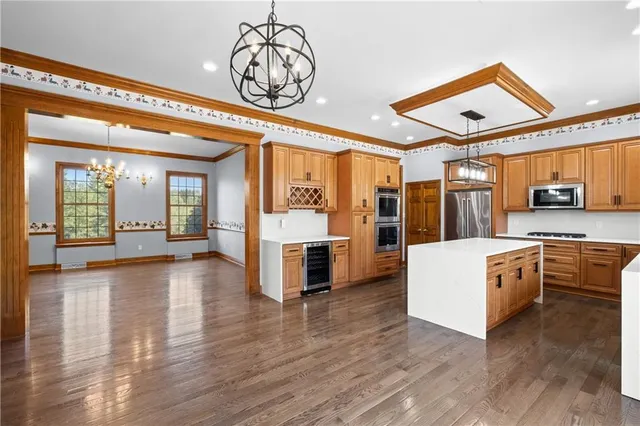 a view of a livingroom with furniture wooden floor and a kitchen