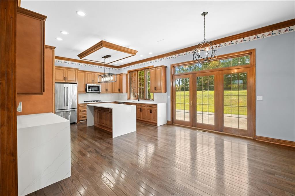 129 Purvis Road Butler, PA 16001 - Photo 12 of 50 a open kitchen with stainless steel appliances granite countertop a stove top oven a sink and white cabinets with wooden floor