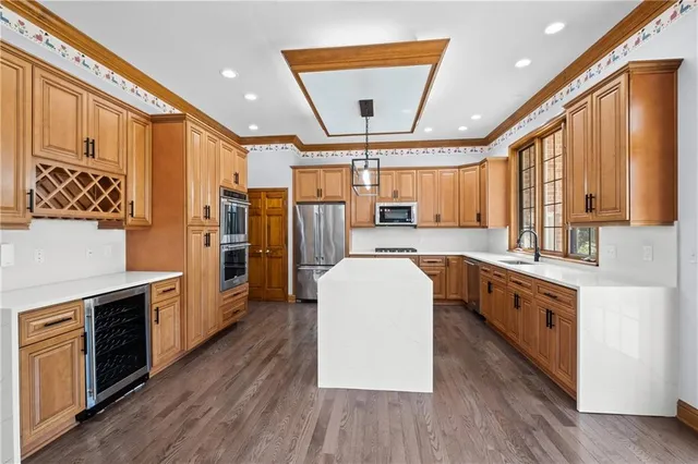 a large kitchen with stainless steel appliances granite countertop a lot of counter space and wooden floors