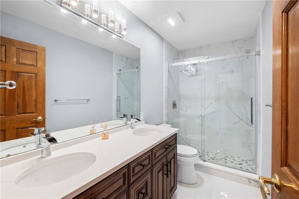 129 Purvis Road Butler, PA 16001 - Photo 43 of 50 a bathroom with a granite countertop sink a toilet a mirror and shower