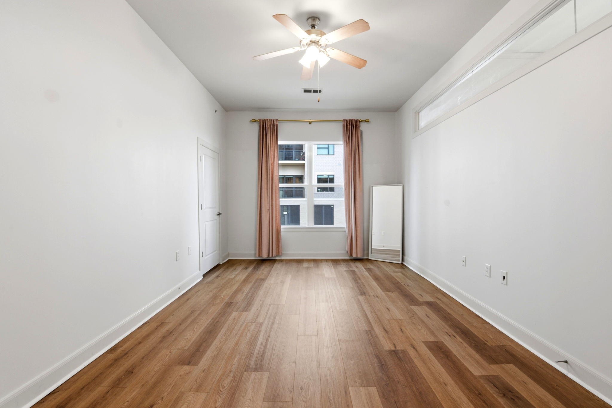 1010 Rosine Street, Unit 43 Houston, TX 77019 - Photo 29 of 48 an empty room with wooden floor chandelier fan and windows