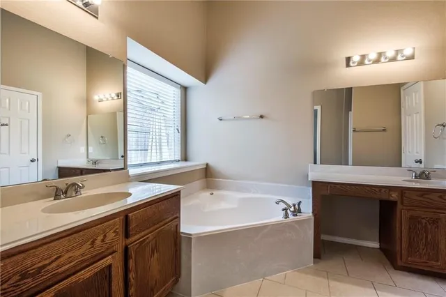 a bathroom with a tub sink and mirror