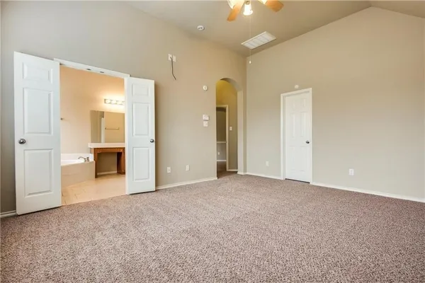 an empty room with kitchen and windows