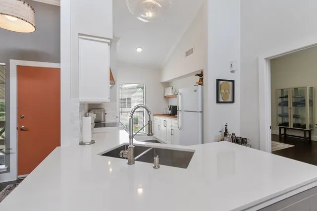 a kitchen with sink refrigerator and cabinets