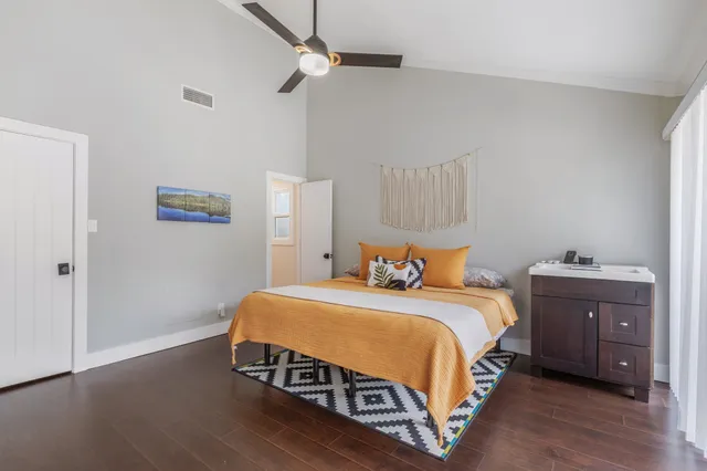 a bedroom with a bed and wooden floor