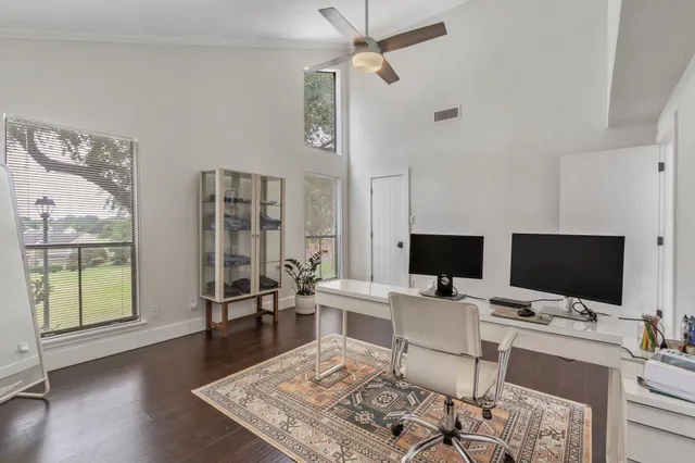 a work room with furniture a flat screen tv and a floor to ceiling window