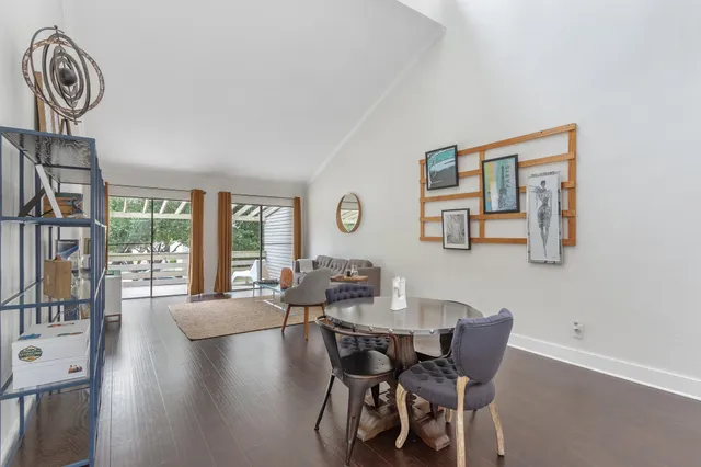 a dining room with furniture a large window and wooden floor