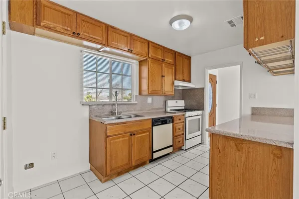 a kitchen with stainless steel appliances granite countertop a sink and a refrigerator