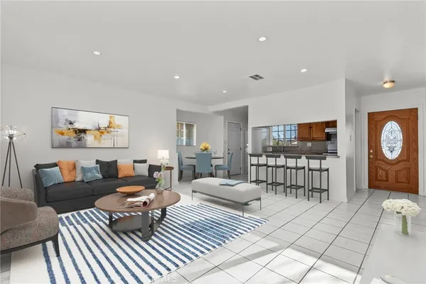a living room with furniture a flat screen tv and a table