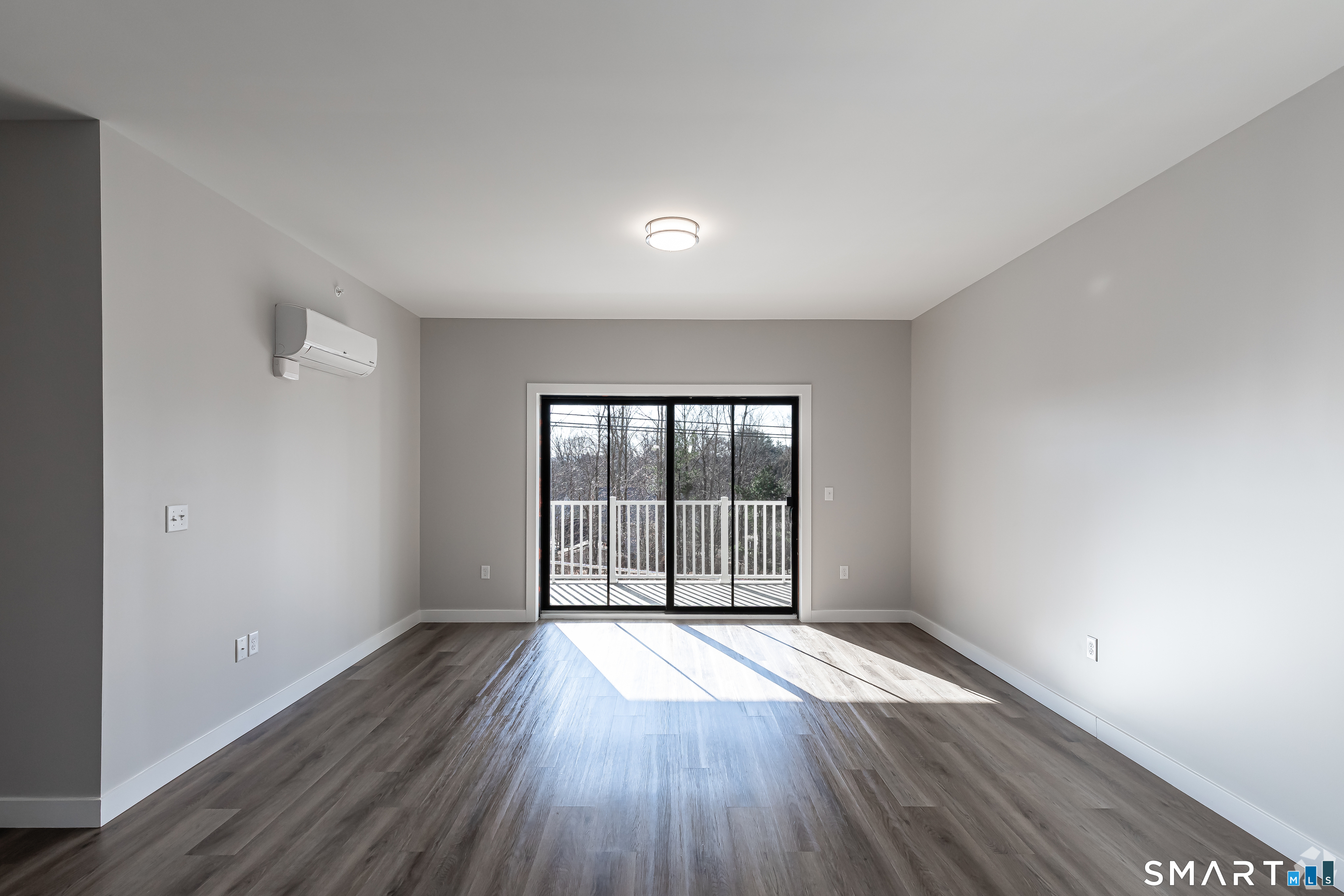 401 Albany Turnpike, Unit 213 Canton, CT 06019 - Photo 2 of 11 an empty room with wooden floor and windows