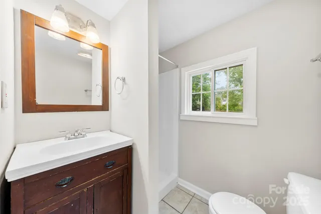 a bathroom with a sink vanity mirror and toilet