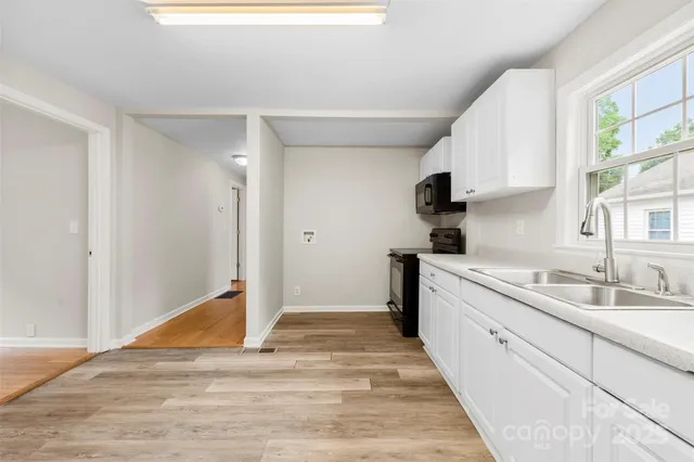 a kitchen with granite countertop a sink stainless steel appliances and cabinets
