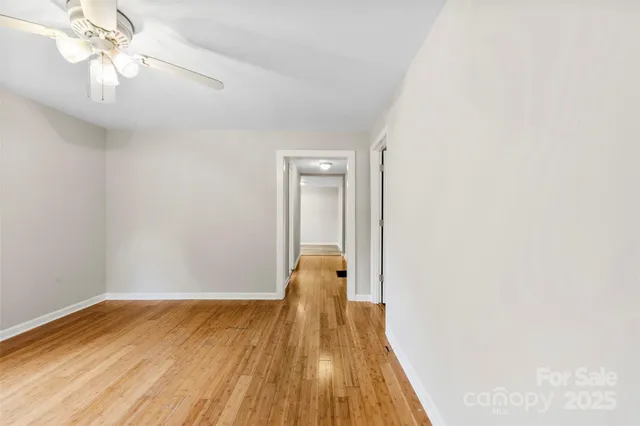 a view of a room with wooden floor and ceiling fan