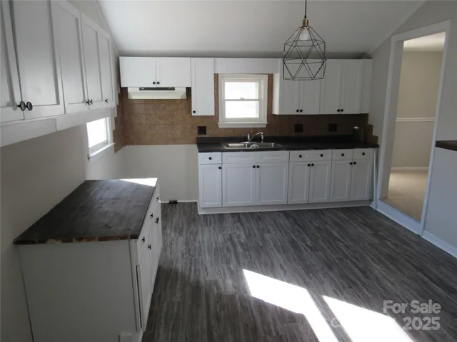 a kitchen with granite countertop a sink a counter space stainless steel appliances and cabinets