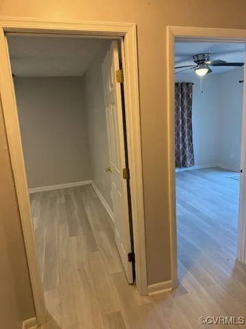 a view of a hallway with wooden floor and closet