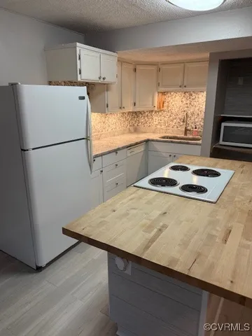 a kitchen with sink a refrigerator and window