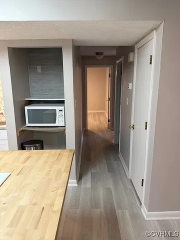 a view of a hallway with wooden floor and staircase