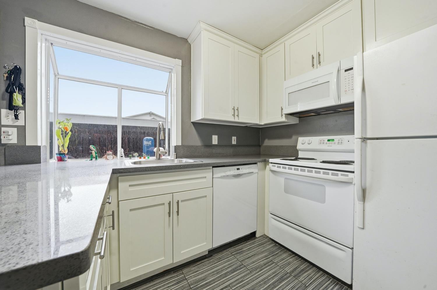 27 Omaha Court Sacramento, CA 95823 - Photo 12 of 43 a kitchen with white cabinets and white appliances
