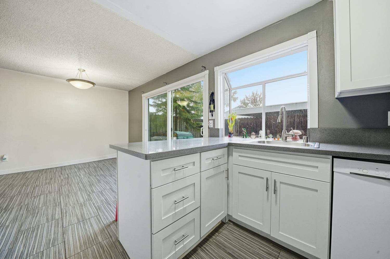 27 Omaha Court Sacramento, CA 95823 - Photo 16 of 43 a kitchen with white cabinets and wooden floors