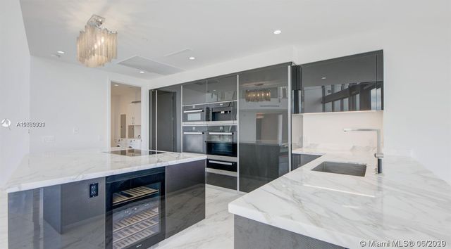 a large kitchen with a table chairs stainless steel appliances and cabinets