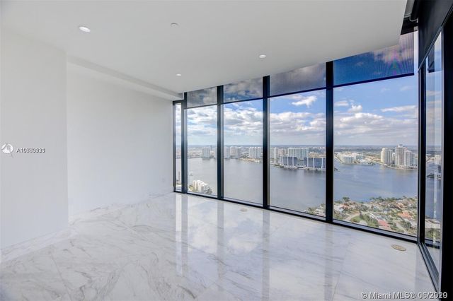 a view of an empty room with glass door and windows