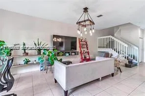 a living room with furniture and a chandelier