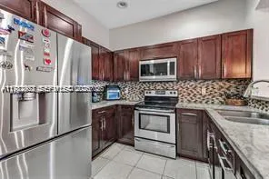 a kitchen with granite countertop a sink stove and microwave