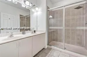 a bathroom with a shower sink and mirror