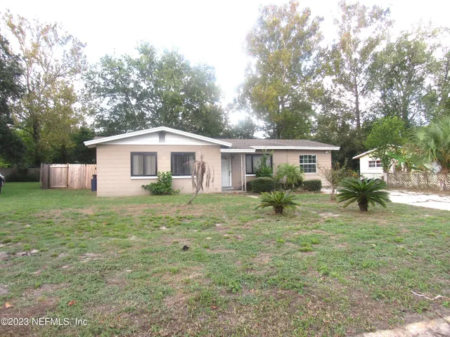 a backyard of a house with table and chairs