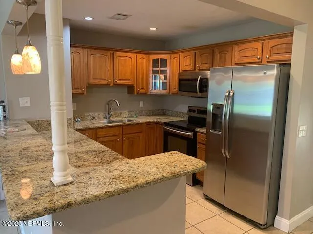 a kitchen with stainless steel appliances granite countertop a sink a stove and a refrigerator