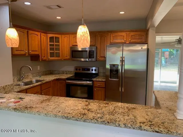 a kitchen with granite countertop a refrigerator and a sink