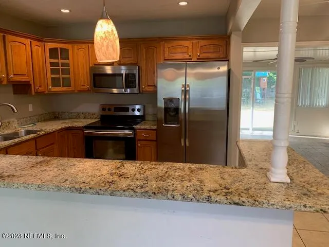 a kitchen with stainless steel appliances granite countertop a sink a stove and a refrigerator