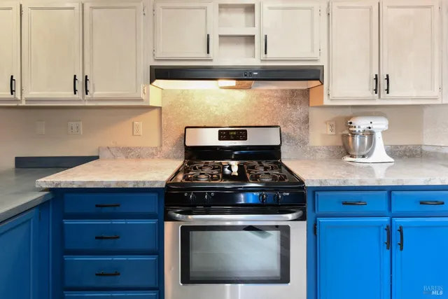 a stove top oven sitting inside of a kitchen and granite counter tops