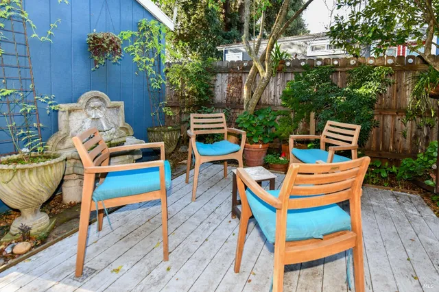a view of a backyard with chair and potted plants