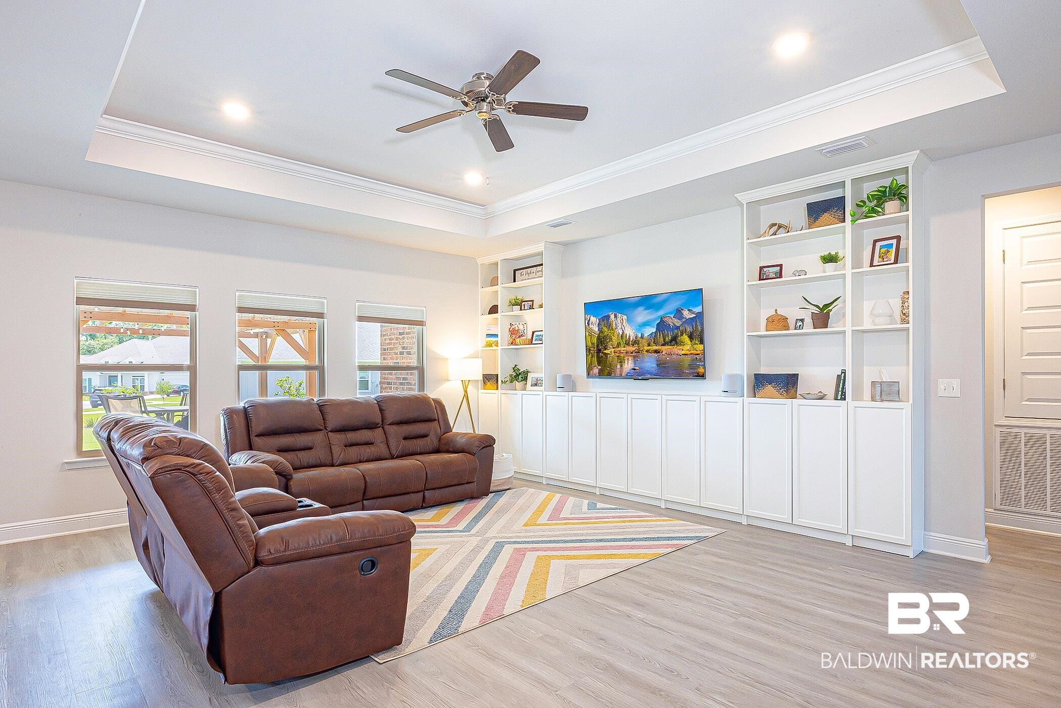 11044 Native Dancer Way Daphne, AL 36526 - Photo 7 of 67 Living room featuring light hardwood / wood-style floors, a raised ceiling, ornamental molding, and ceiling fan