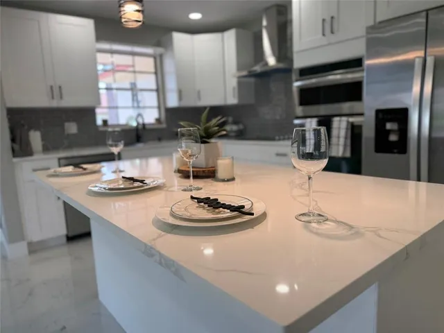 a kitchen with a sink a stove and chairs with wooden floor