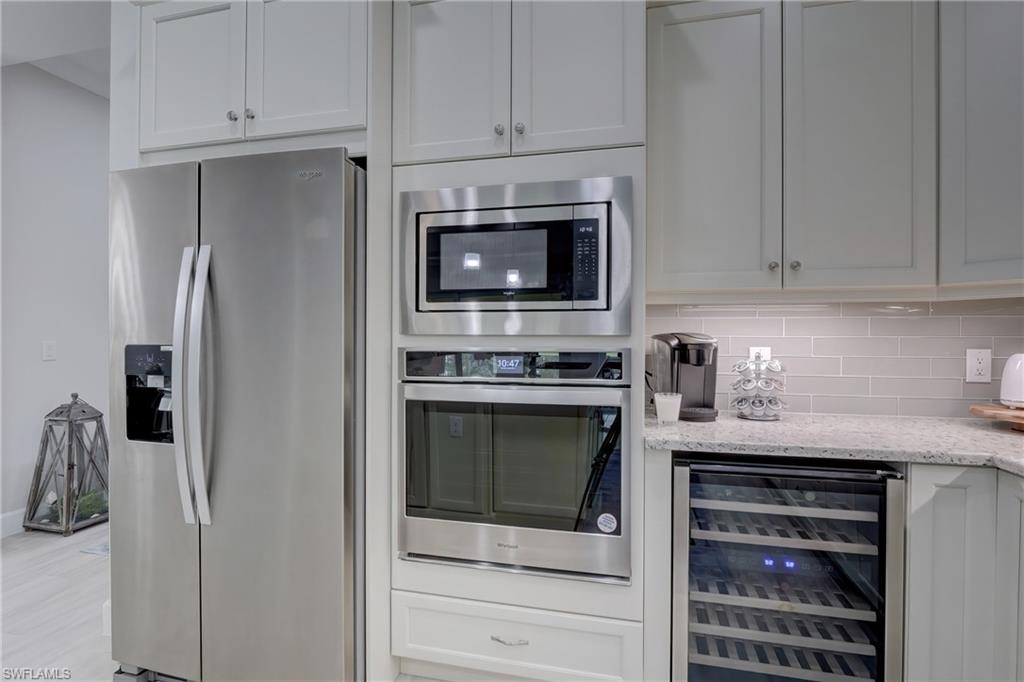6297 Antigua Way Naples, FL 34113 - Photo 12 of 43 a kitchen with stainless steel appliances white cabinets and a stove