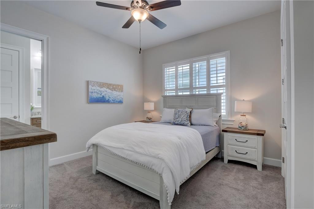 6297 Antigua Way Naples, FL 34113 - Photo 19 of 43 a bedroom with a bed and a chandelier