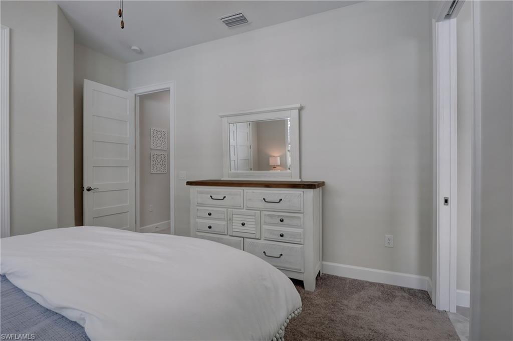 6297 Antigua Way Naples, FL 34113 - Photo 20 of 43 a bedroom with a bed and a dresser