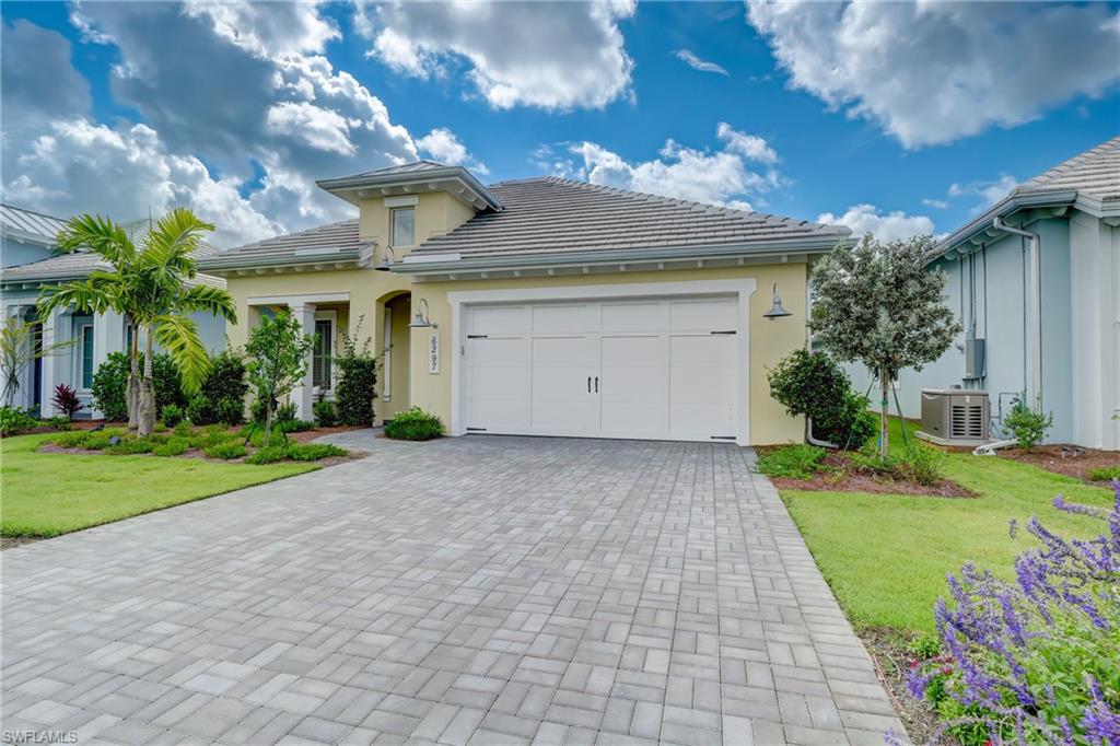 6297 Antigua Way Naples, FL 34113 - Photo 2 of 43 a view of a white house with a yard and potted plants