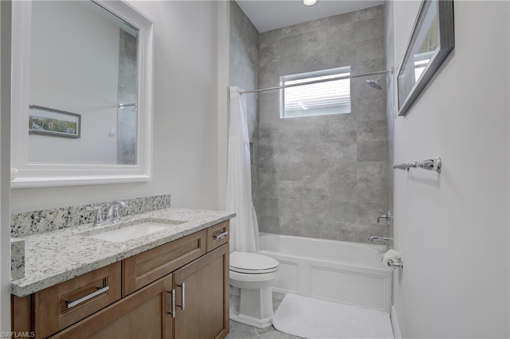6297 Antigua Way Naples, FL 34113 - Photo 21 of 43 a bathroom with a granite countertop sink a toilet and shower