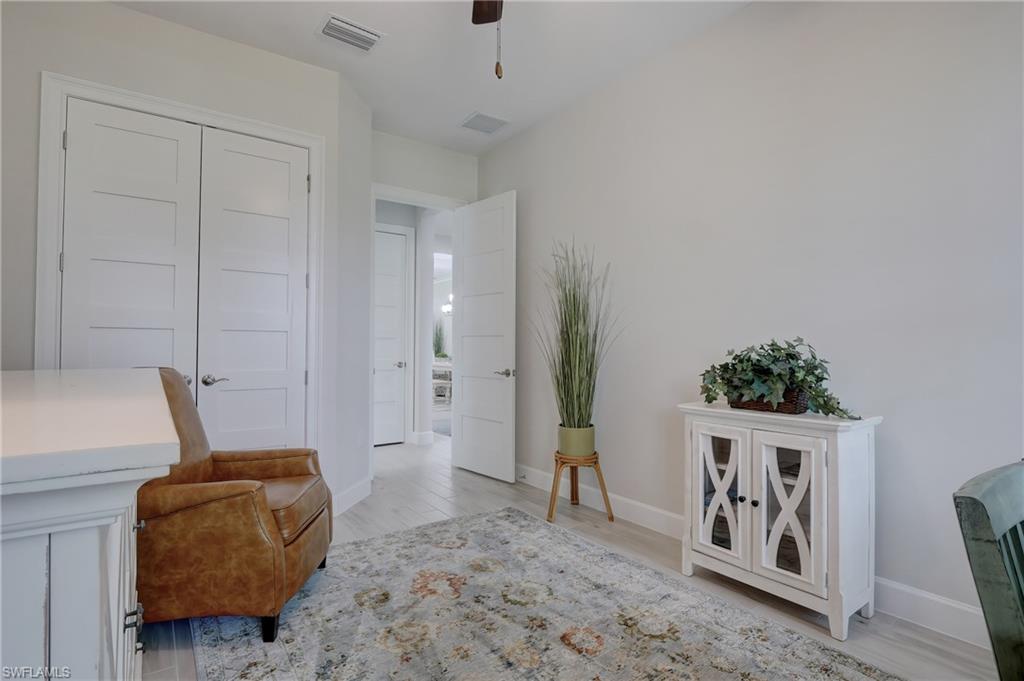 6297 Antigua Way Naples, FL 34113 - Photo 24 of 43 a living room with furniture and a potted plant