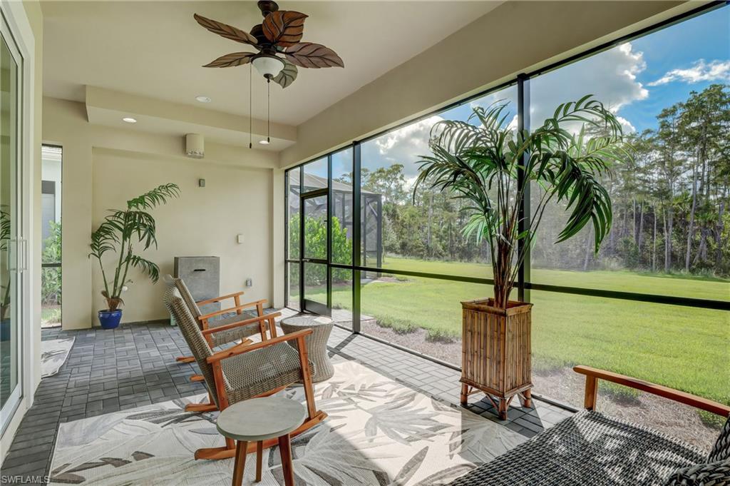6297 Antigua Way Naples, FL 34113 - Photo 27 of 43 a living room with furniture and a floor to ceiling window