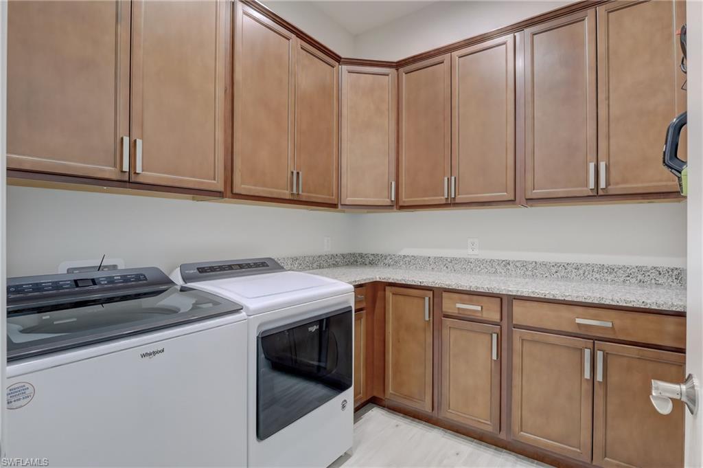 6297 Antigua Way Naples, FL 34113 - Photo 29 of 43 a kitchen with granite countertop white cabinets and sink