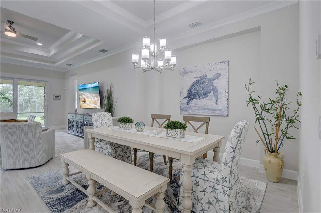 6297 Antigua Way Naples, FL 34113 - Photo 8 of 43 a view of a dining room with furniture a chandelier and wooden floor