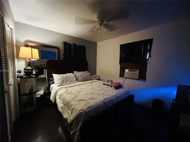 a bed sitting in a bedroom next to a window with pc on the table
