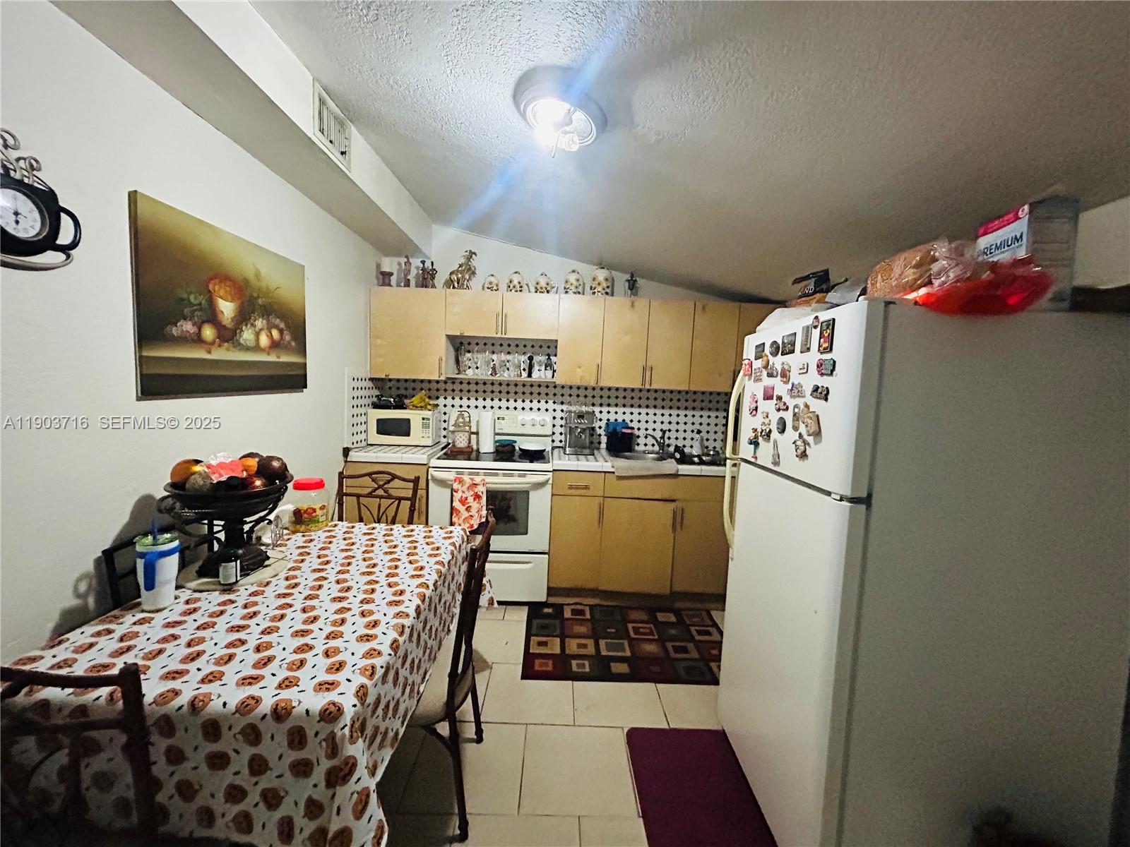 244 Southwest 36th Avenue Miami, FL 33135 - Photo 10 of 17 a kitchen with stainless steel appliances a refrigerator and a stove top oven