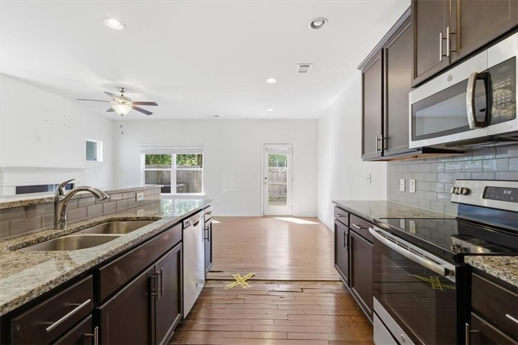 5064 Longview Walk Decatur, GA 30035 - Photo 17 of 30 a kitchen with stainless steel appliances granite countertop a sink stove and cabinets